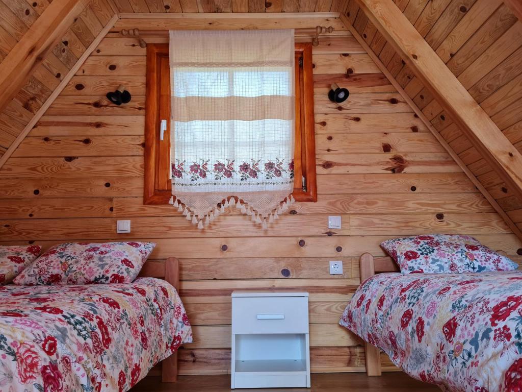 a bedroom with two beds in a log cabin at Guest House Rankić in Mokra Gora