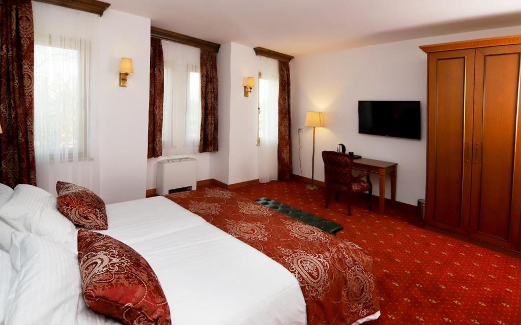 a hotel room with a bed and a television at Hotel Vila Zana in Gostivar
