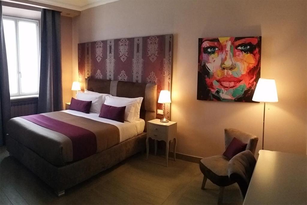 ネットゥーノにあるHalex room&foodのベッド付きの客室で、壁には絵画が飾られています。