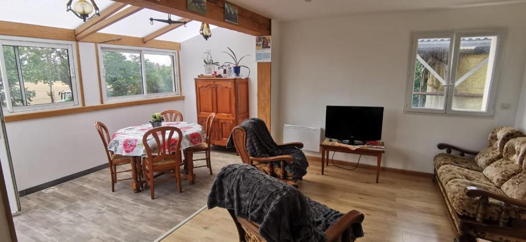 a living room with a table and a couch at Le Repos des Crins Noirs in Esson