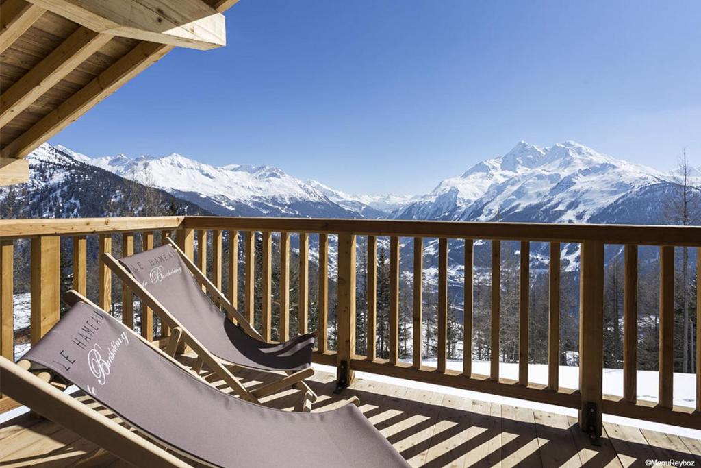 una panchina su una terrazza con vista sulle montagne di TERRESENS - Le Hameau de Barthélémy a La Rosière