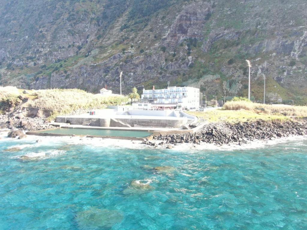 uma vista para uma massa de água com uma montanha em Calamar Hotel em São Vicente