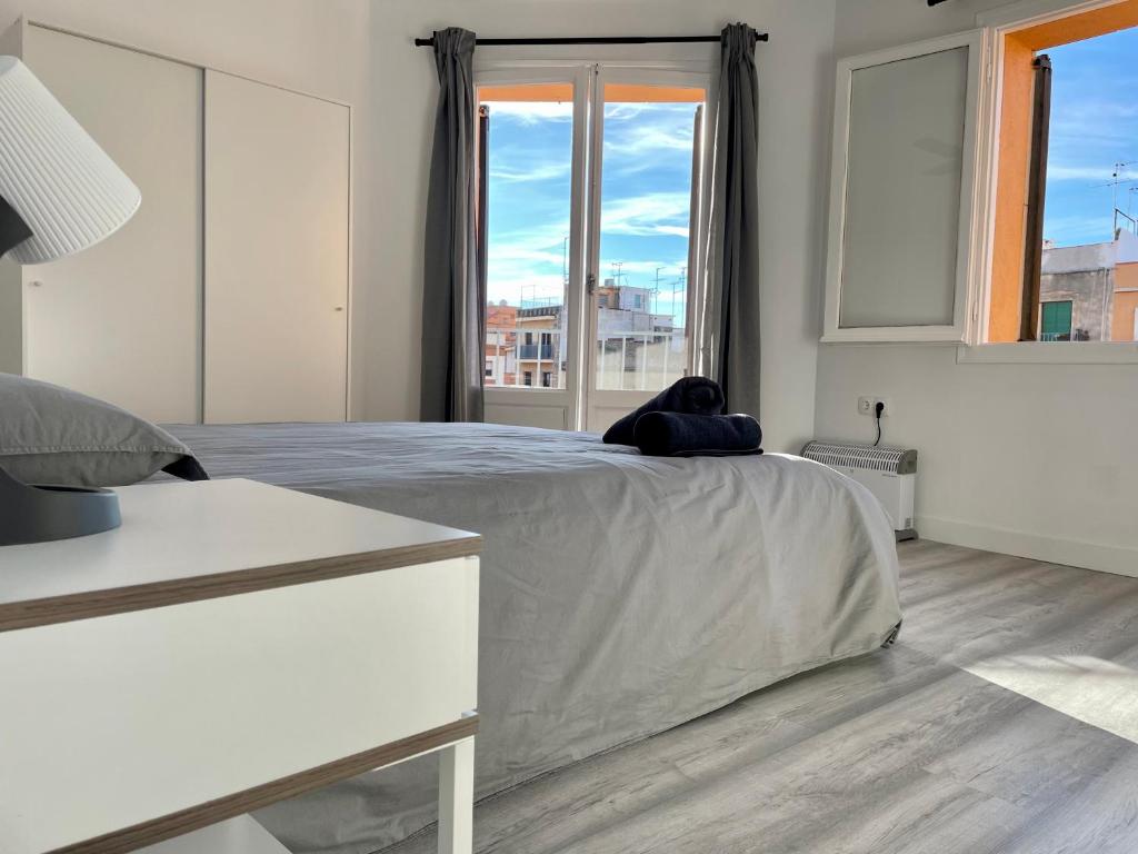 Habitación blanca con cama y ventana en Hermoso piso con vistas en Part Alta de Tarragona! en Tarragona