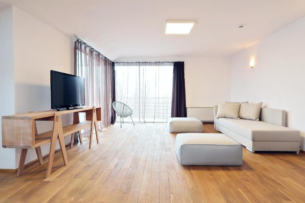 a living room with a couch and a tv at Living In Aparthotel in Oradea