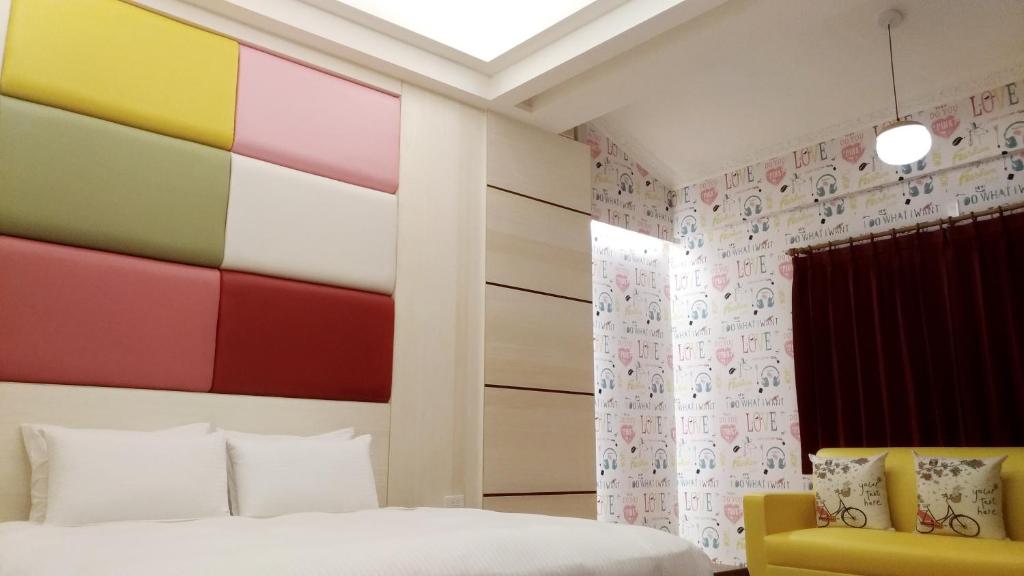 ein Schlafzimmer mit einer farbenfrohen Wand mit Akzenten in der Unterkunft Keton Motel Hualien in Hualien