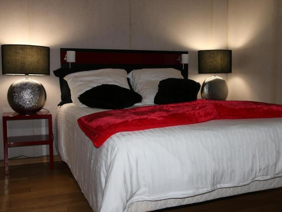 a bedroom with a large white bed with two lamps at Marinha Hotel in Gentilly