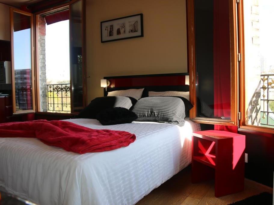 a bedroom with a large bed with a red end table at Marinha Hotel in Gentilly