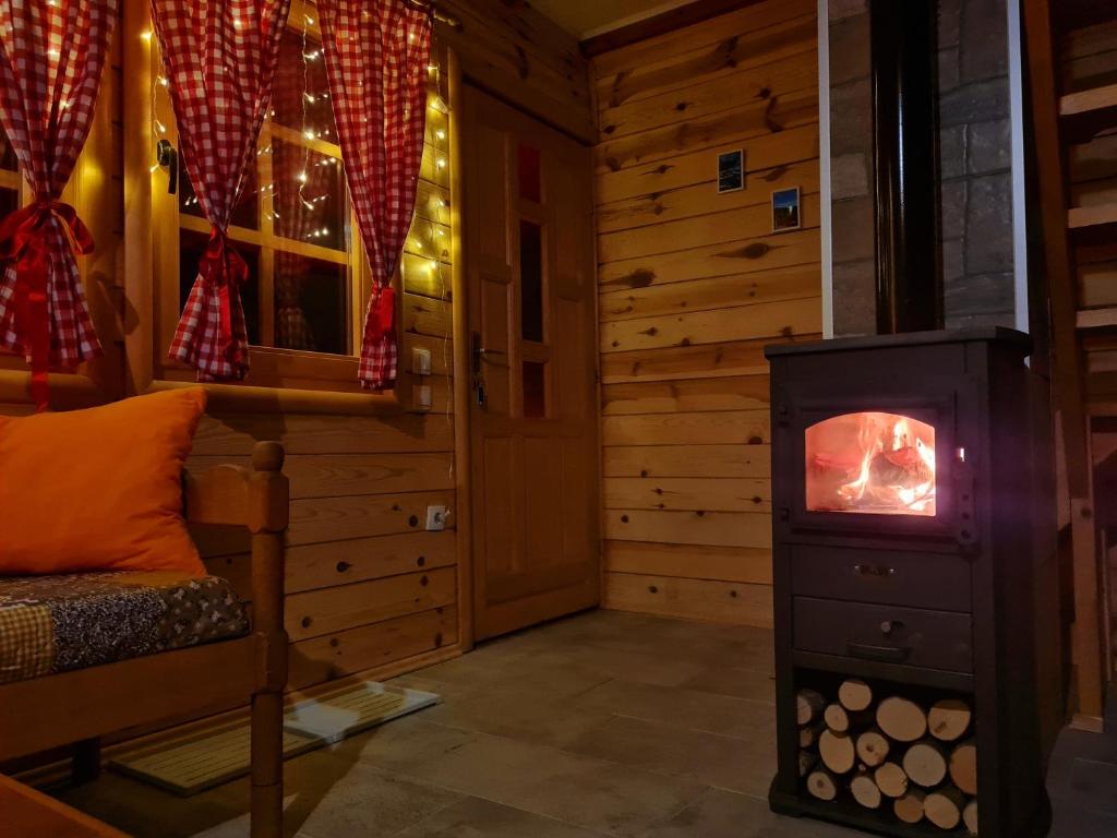 a room with a wood stove in a log cabin at Guest House Rankić in Mokra Gora