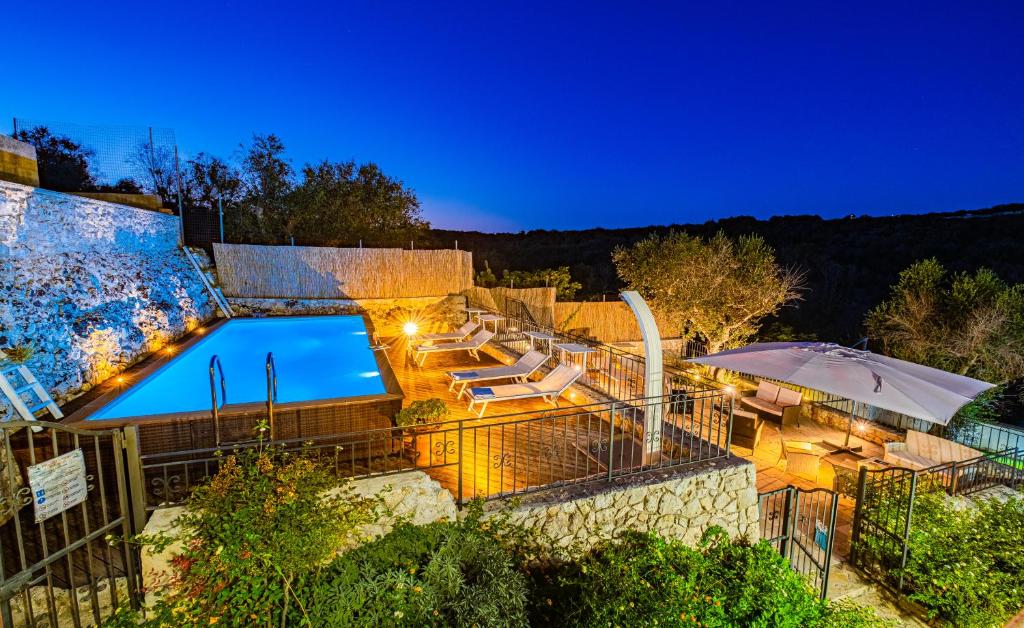 カストロ・ディ・レッチェにあるVilla Vanessa con Piscina Privata - Castroのラウンジチェアとパラソル付きのスイミングプールを併設しています。