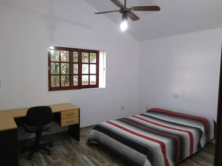 a bedroom with a bed and a desk and a window at Casa Tranquila en pasaje , Villa Carlos Paz in Villa Carlos Paz