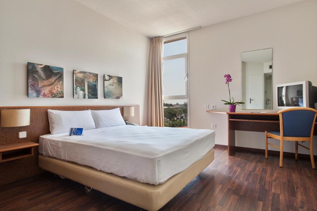 レウスにあるCrisol Quality Reusのベッドとデスクが備わるホテルルームです。