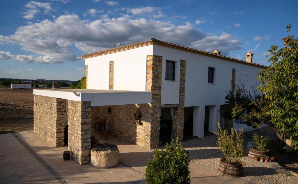 Casa blanca con un edificio de piedra en Alojamiento rural La Granja de Las Monjas, en Jaén