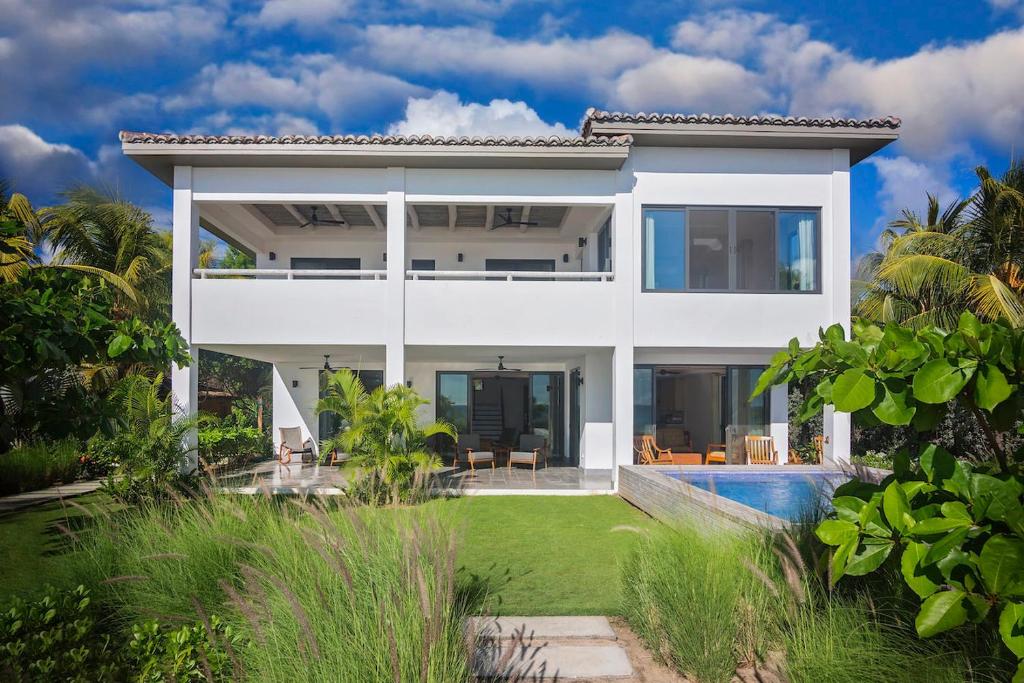 a white villa with a swimming pool at Iguana Beach House in Iguana