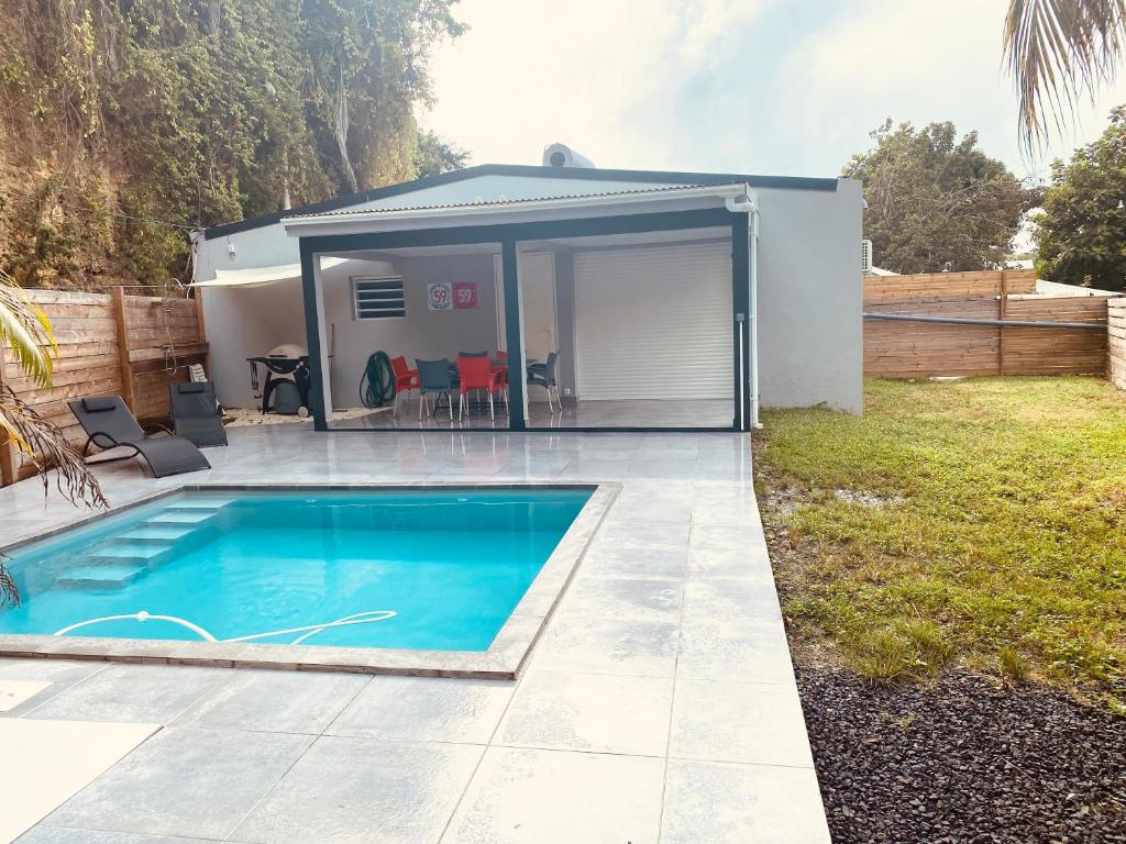 una pequeña piscina en un patio trasero con un cobertizo en VILL'ARBOREE, en Les Abymes