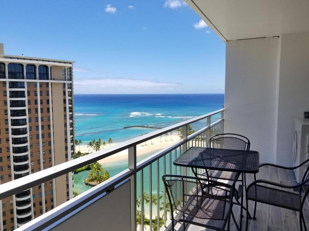 d'un balcon avec une table et des chaises donnant sur l'océan. dans l'établissement Ilikai Tower 2136 Lagoon View 1BR, à Honolulu