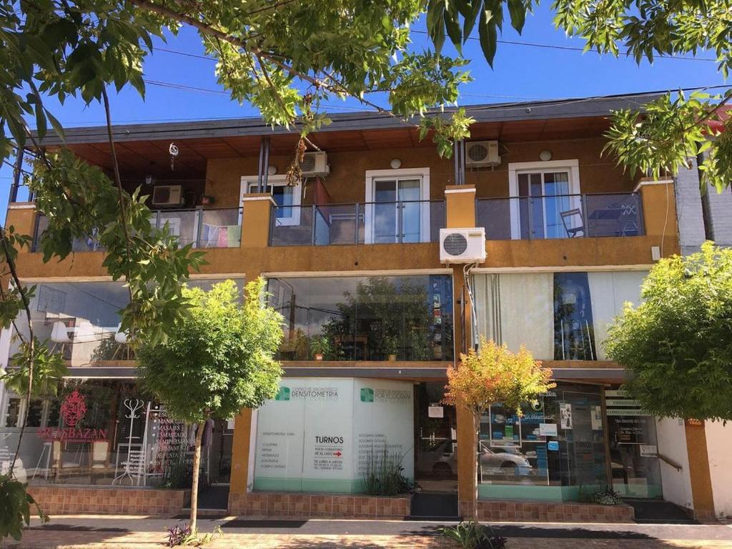 an apartment building with a balcony in front of it at Paz y Armonia Habitaciones in Mina Clavero