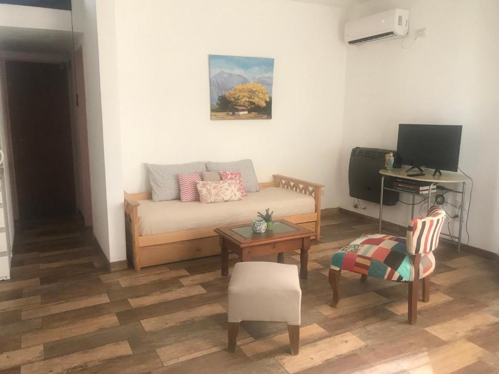 een woonkamer met een bank en een tafel bij PAZ EN LA CIUDAD, en el centro, con WIFI y cochera privada in San Antonio de Areco