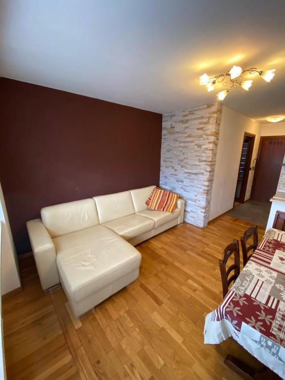 a living room with a white couch and a table at Grazioso monolocale a Sestriere in Sestriere