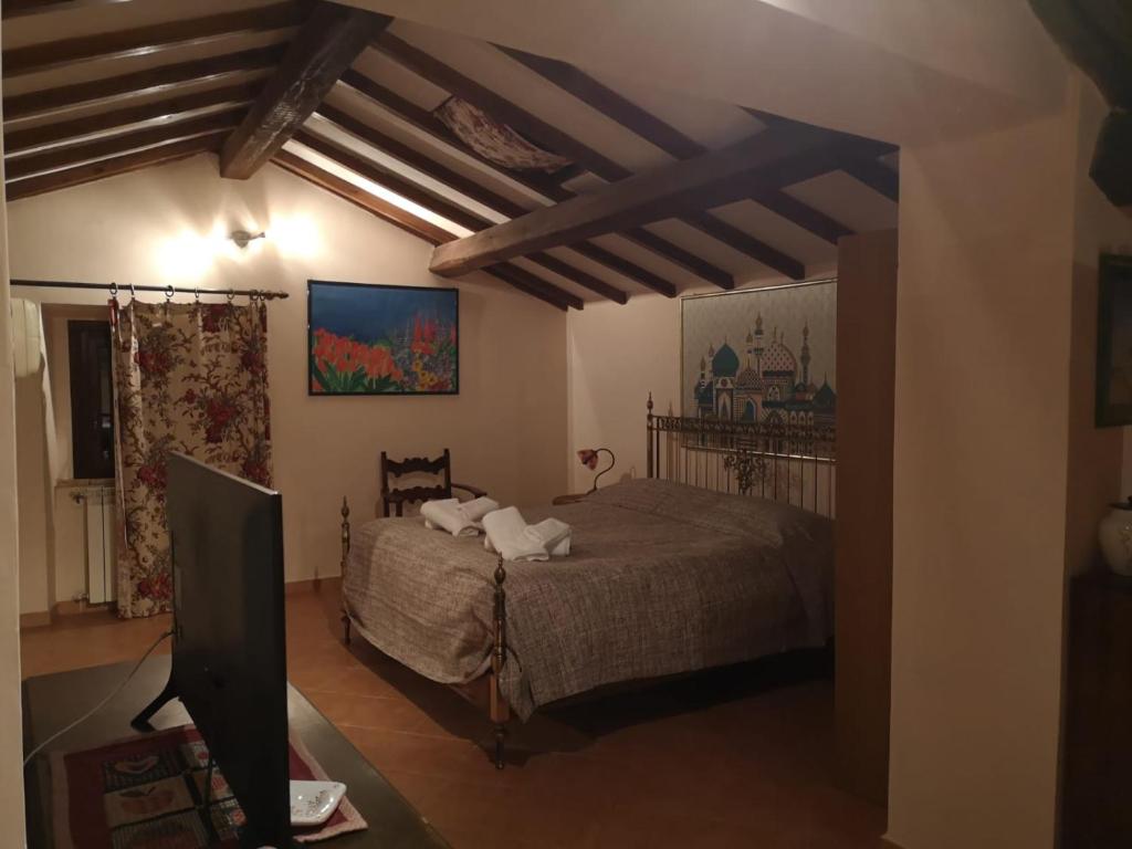 a bedroom with a bed and a flat screen tv at La mansarda del Sacro Bosco in Bomarzo