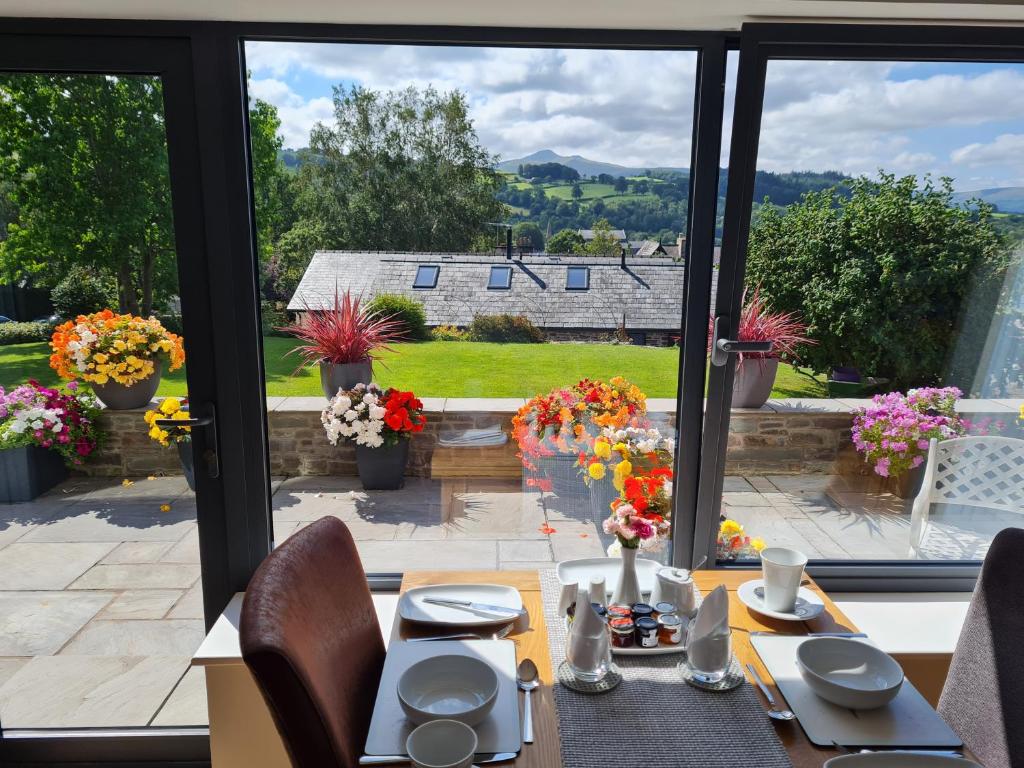 ein Esszimmer mit Gartenblick in der Unterkunft Camden Lodge B&B and Cottage Brecon in Brecon