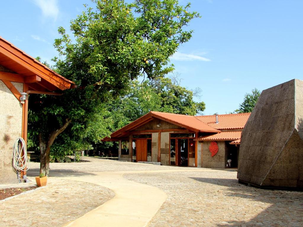 a building with a tree in front of it at LaranjaLimão in Freixo