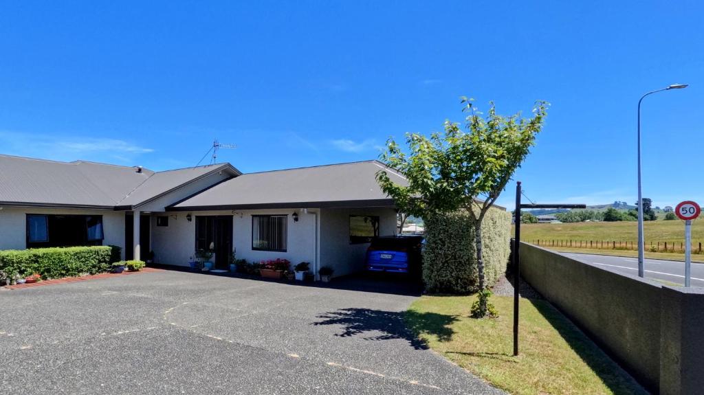 a house with a tree in front of a street at Almost Country in Taupo