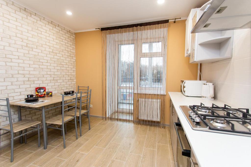 a kitchen with a table and chairs and a stove at Бам. Однокімнатна квартира в новобудові in Ternopilʼ