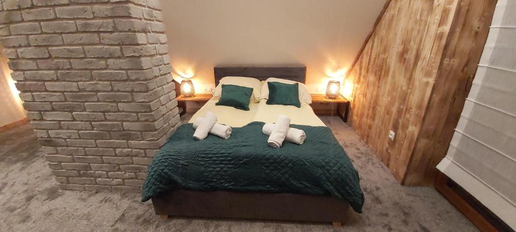 sypialnia z łóżkiem w ceglanej ścianie w obiekcie Rozeta w mieście Jurgów