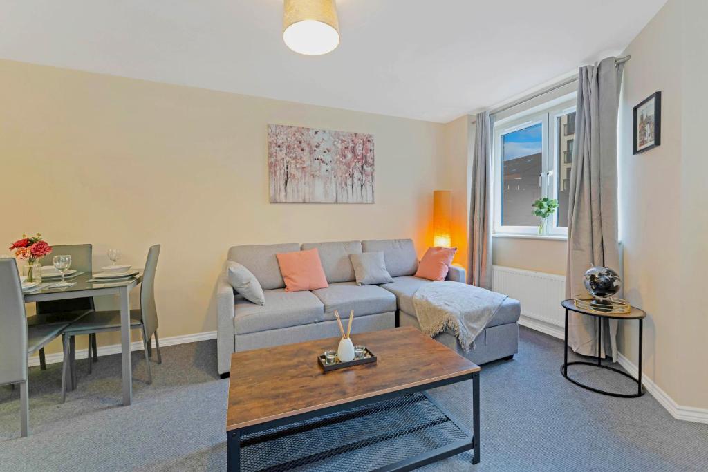 a living room with a couch and a table at Modern & Spacious 2 Bedroom Serviced Apartment Next to Lochend Park - Private Underground Parking & Lift Available - Close to Edinburgh City Centre in Edinburgh