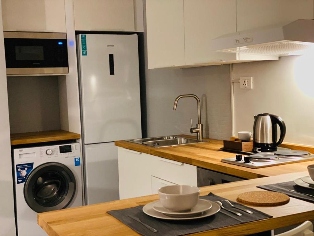 a kitchen with a sink and a refrigerator at Elite Corner Apartment in Ţāb Kirā‘
