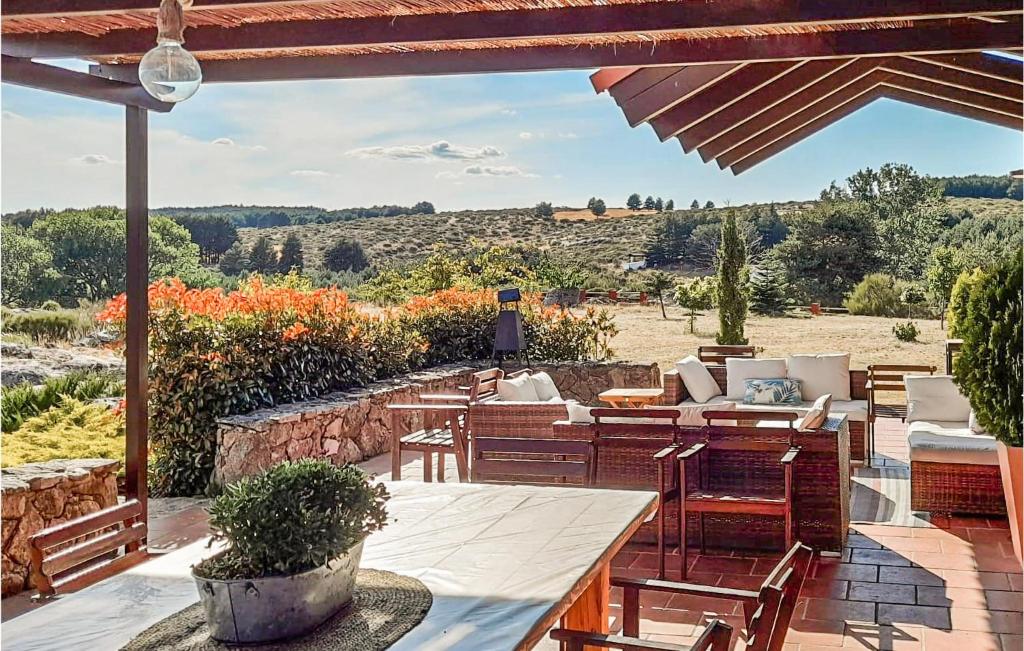 patio con mesa, sillas y vistas en Gorgeous Home In Navarredonda De Gredos With Outdoor Swimming Pool, en Navarredonda de Gredos
