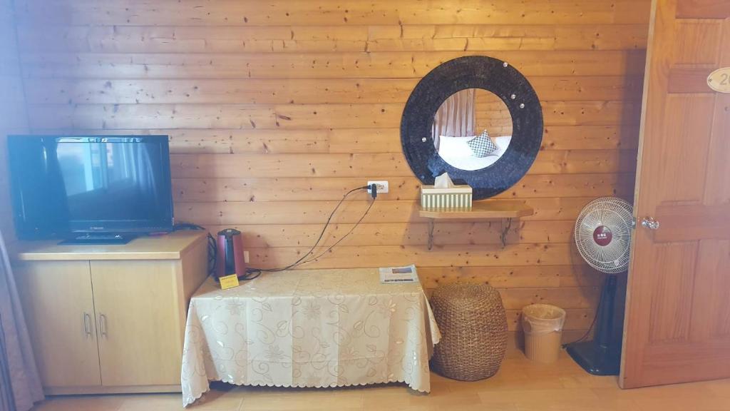 a room with a table and a tv and a mirror at Yosemite Park B&amp;B in Ren&#39;ai