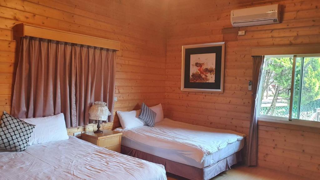 a bedroom with two beds in a log cabin at Yosemite Park B&amp;B in Ren&#39;ai