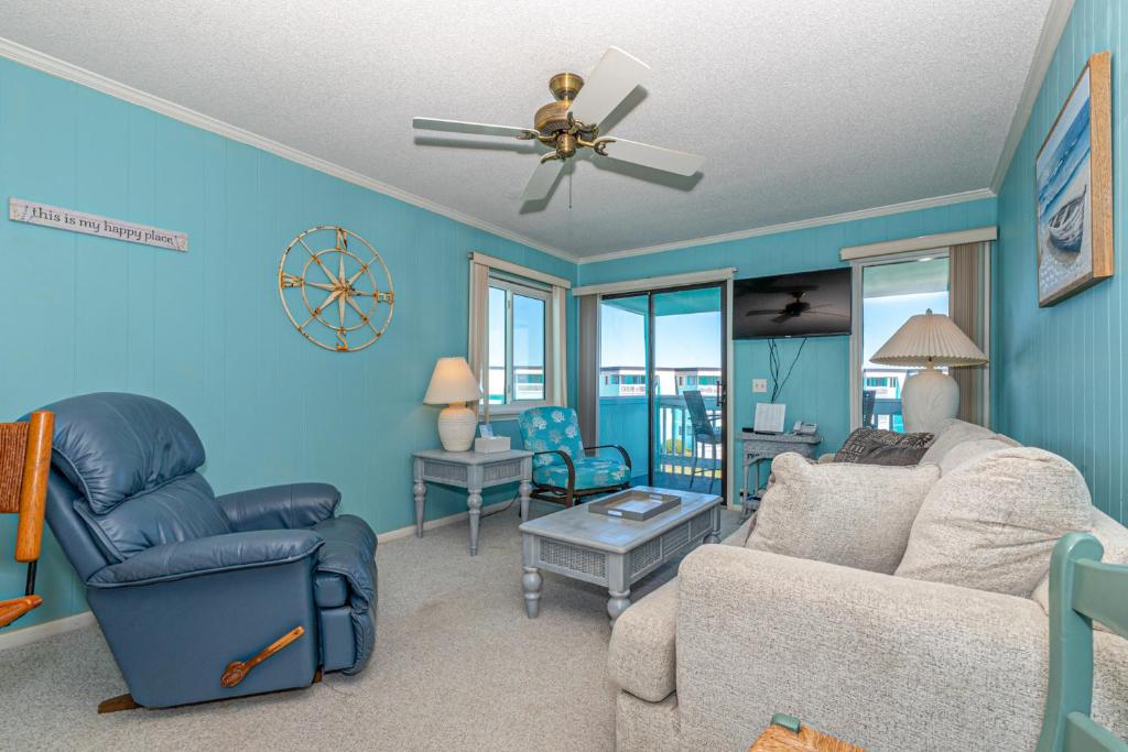 a living room with a couch and a ceiling fan at Seaspray in Atlantic Beach