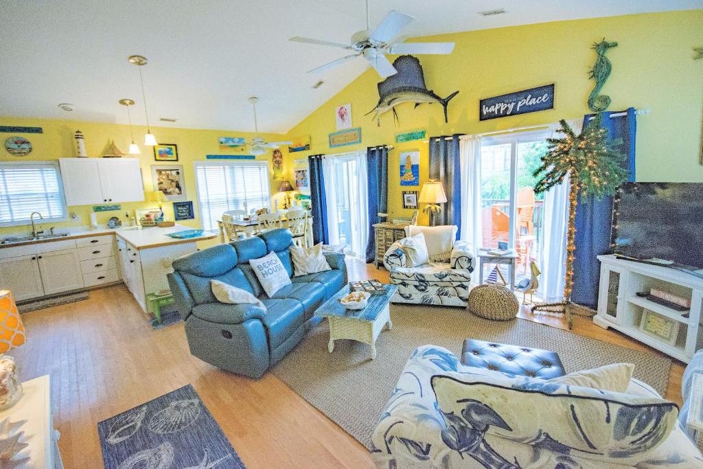 a living room with blue couches and a kitchen at On Island Time in Atlantic Beach