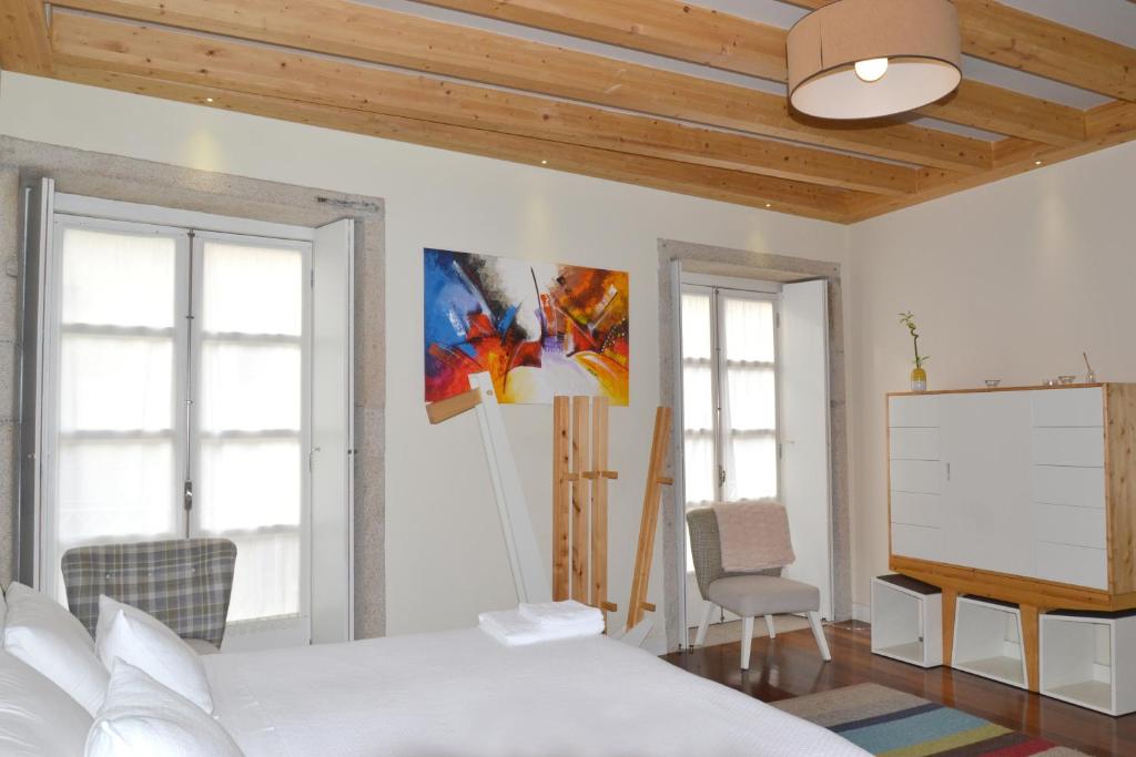 a bedroom with a large white bed and a projector at Stay in the heart of Porto! in Porto