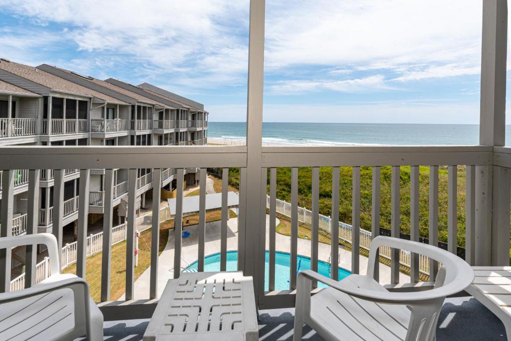 Un balcón con sillas y vistas al océano. en Dunescape Villas en Atlantic Beach