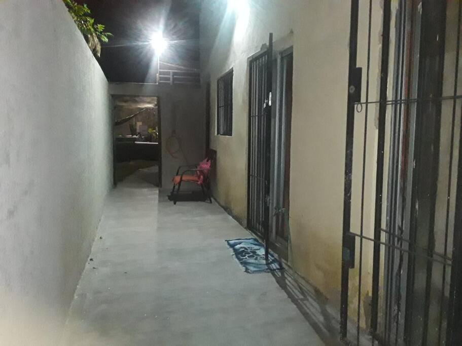 um corredor vazio com uma cadeira vermelha num edifício em N1 2 Apto Pequeño Habitación con baño privado a 120 metros de Plaza Batlle punto Central de la Ciudad em Artigas