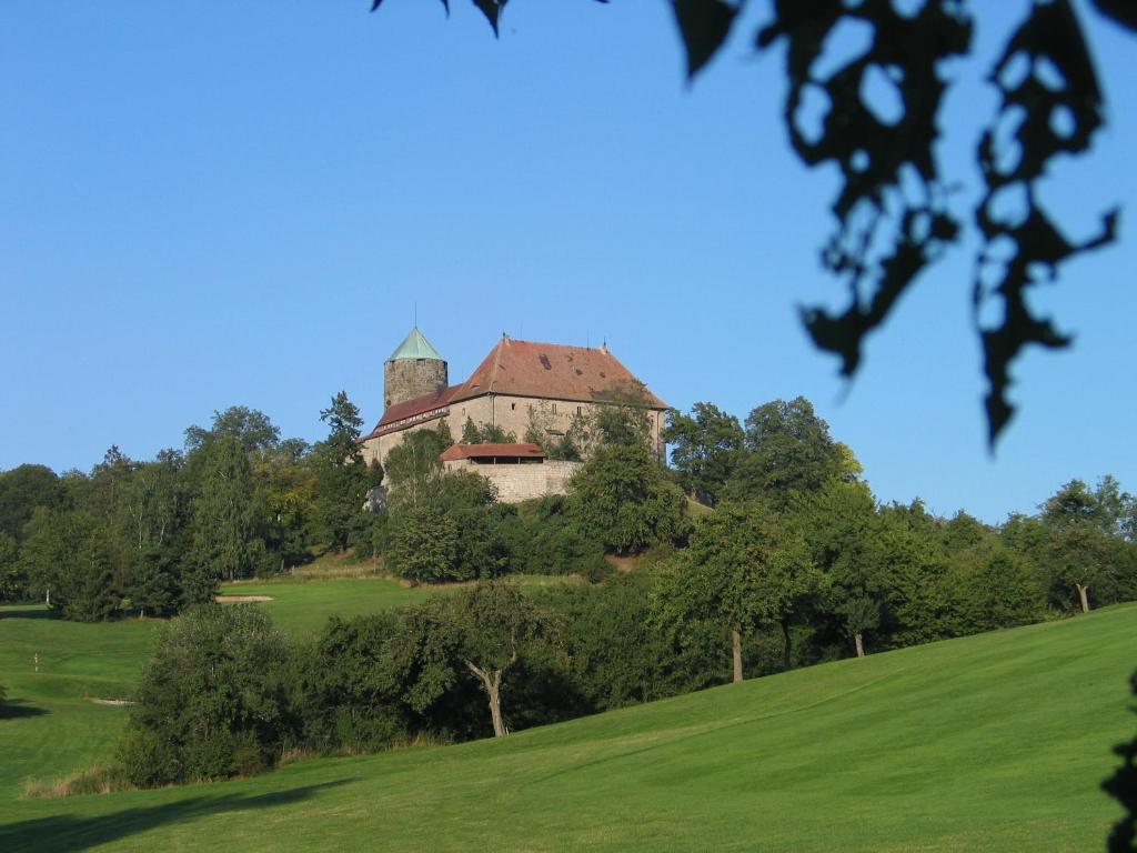 um edifício no topo de uma colina com árvores em Burg Colmberg Hotel em Colmberg