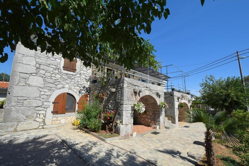 a stone house with a stone facade at Apartments Insula Insule - rustic & peaceful in Skrbčići