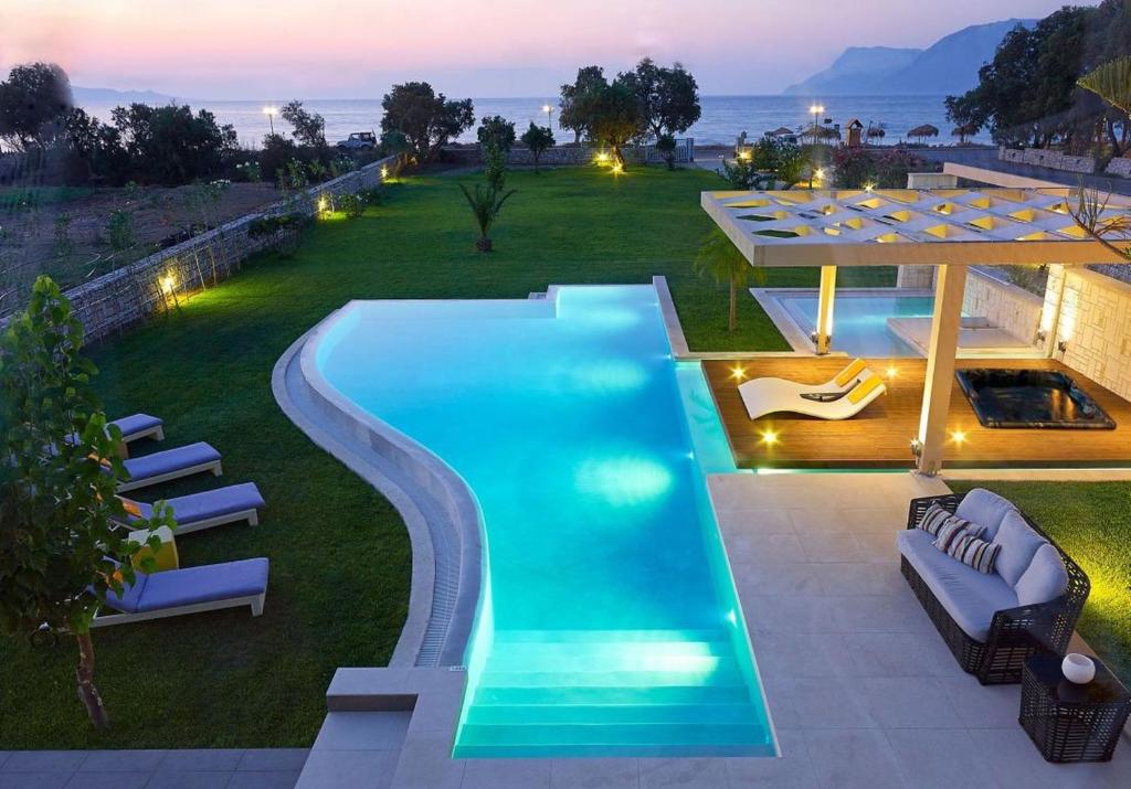 una piscina en un patio con sillas alrededor en Villa Elvina en Kíssamos