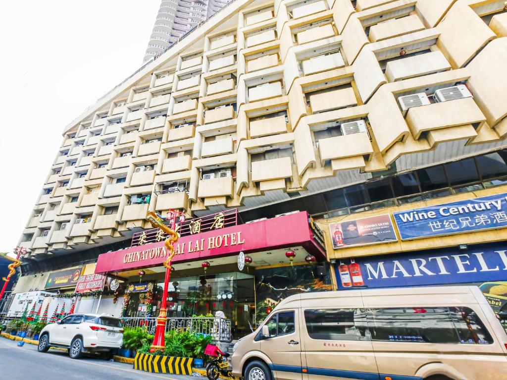 uma carrinha estacionada em frente a um grande edifício em Chinatown Lai Lai Hotel Inc em Manila