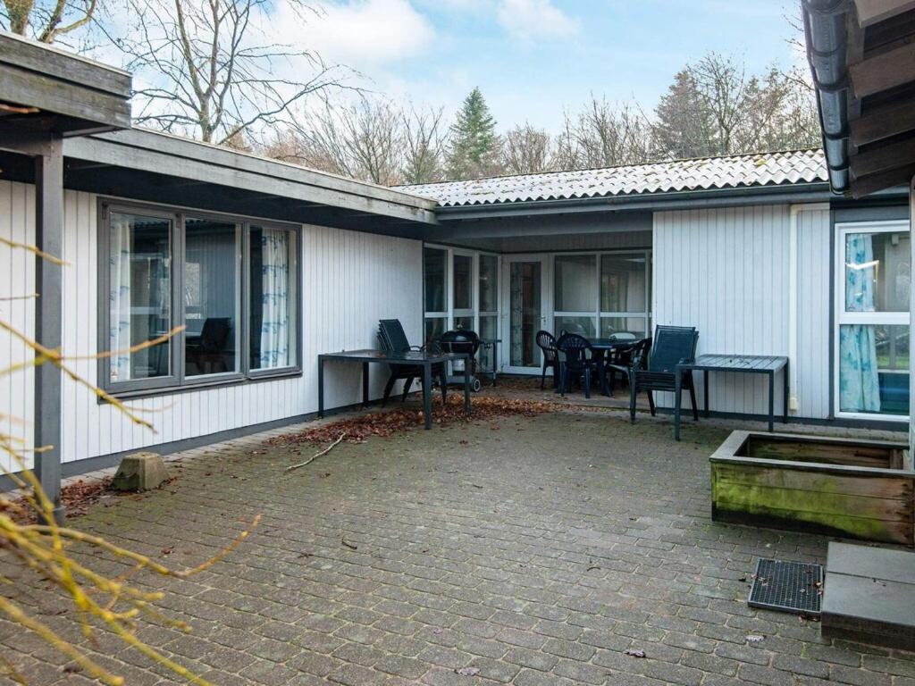 een huis met een patio met stoelen en een tafel bij Holiday Home Lunøes II in Fjellerup