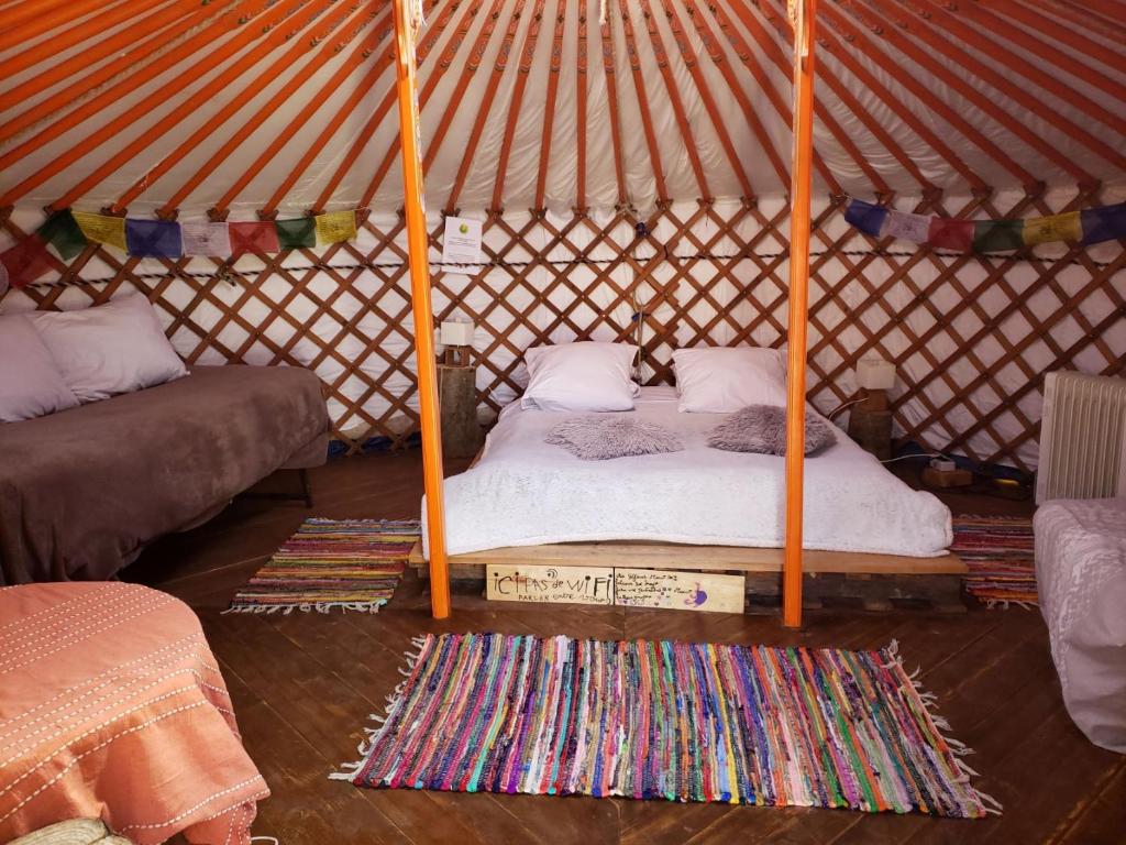 una camera con un letto in una yurta con un tappeto di Yourte 4 personnes proche Provins et Disney a Bannost