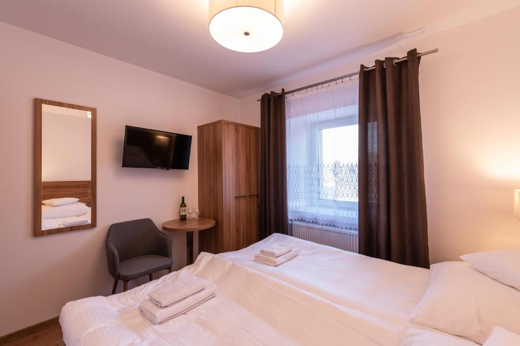a bedroom with two beds and a mirror and a chair at Apartamenty ZYGFRYD 28C/1 in Bystrzyca Kłodzka