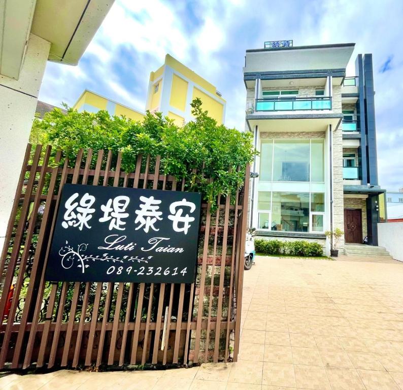 a gate with a sign in front of a building at 綠堤泰安民宿 in Taitung City