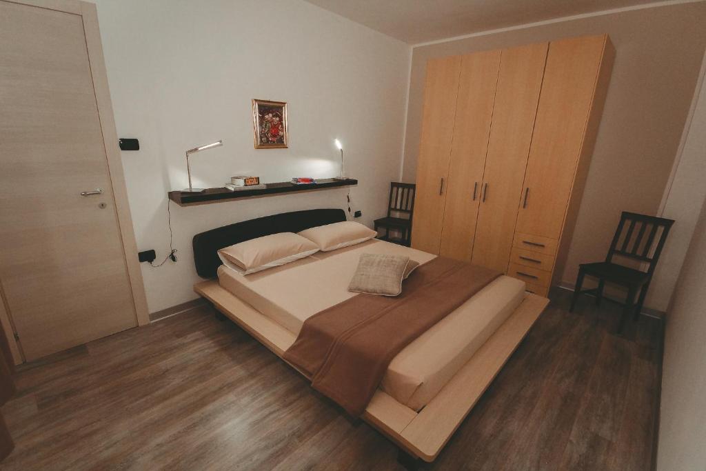 - une chambre avec un grand lit et du parquet dans l'établissement L'Adret, à Aoste