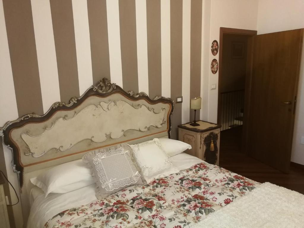 アレッツォにあるCASA LE ROSEの花柄のベッドカバーと枕が付いたベッド1台