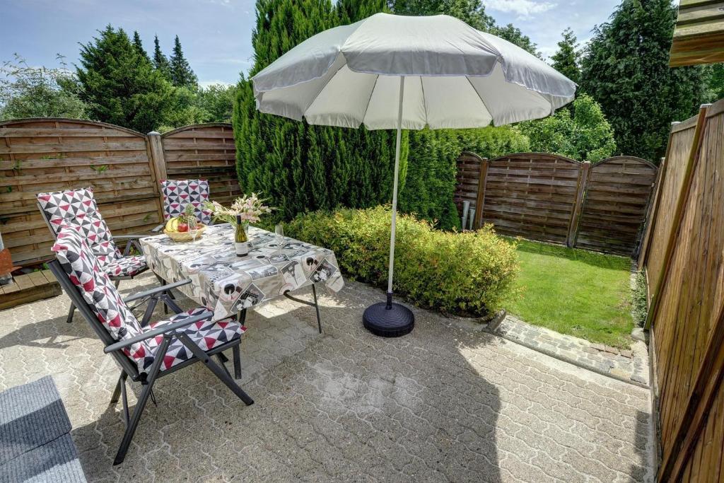 een tafel en stoelen met een parasol op een patio bij Ferienwohnung Aneta in Flensburg