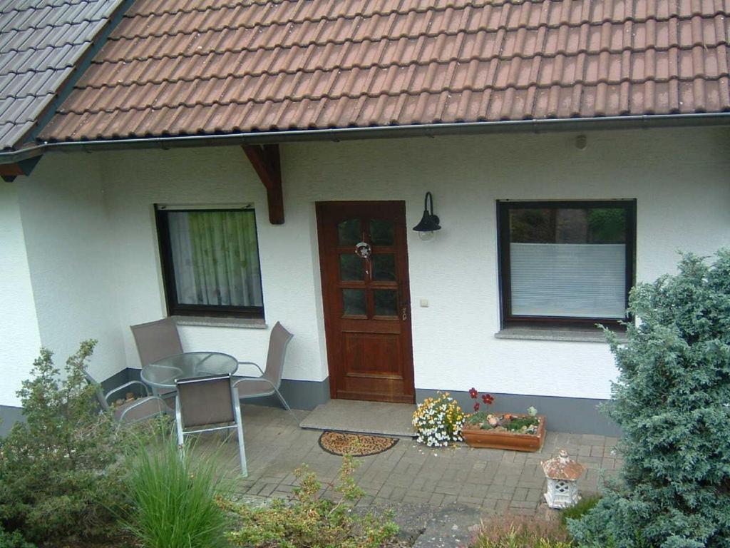 a house with a patio with a table and chairs at Ferienwohnung Hergenröder in Riedenberg
